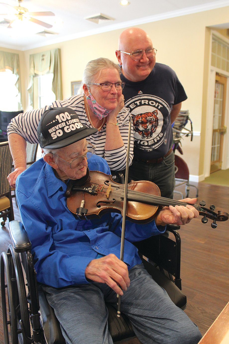 Soon-to-be centenarian Archie Krout shows the staff and residents of Bickford Memory Care that he can still play a mean fiddle Wednesday ahead of his 100th birthday alongside his daughter and son-in-law Linda and Mike McKinnon.